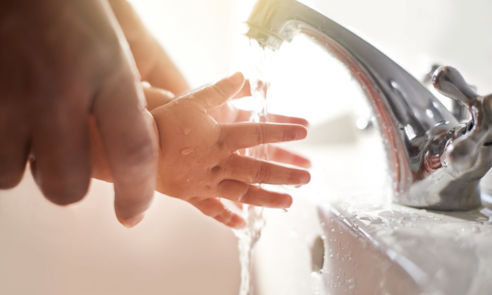 Parent helping their child wash their hands at Shady Grove Apartments in Derwood, Maryland