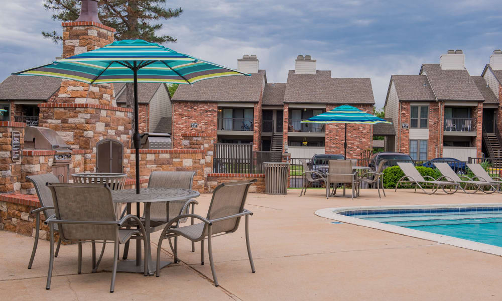 A table with an umbrella by the pool at The Warrington Apartments in Oklahoma City, OK