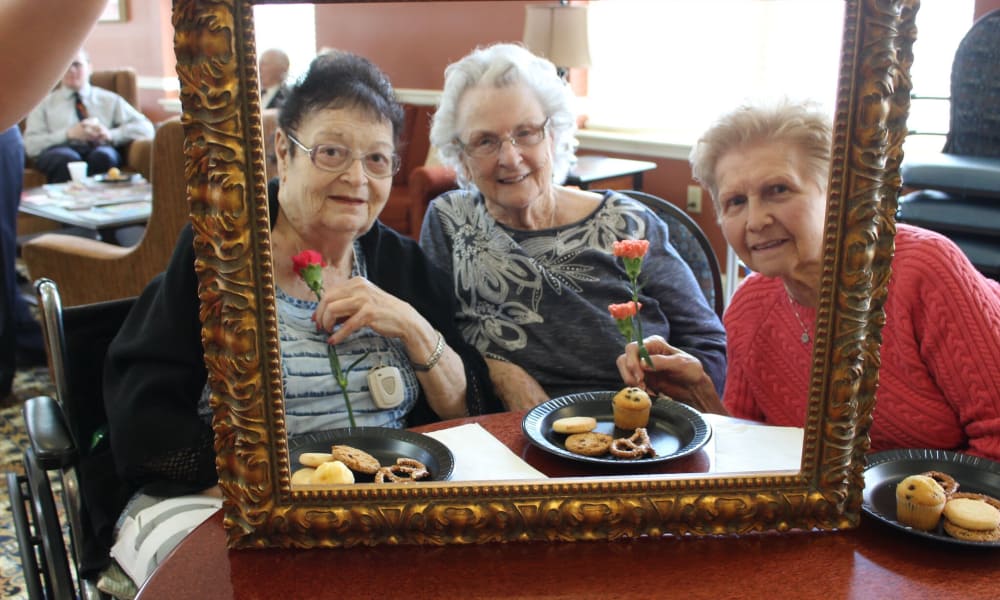 Three residents posing in a photo frame at The Birches at Newtown in Newtown, Pennsylvania