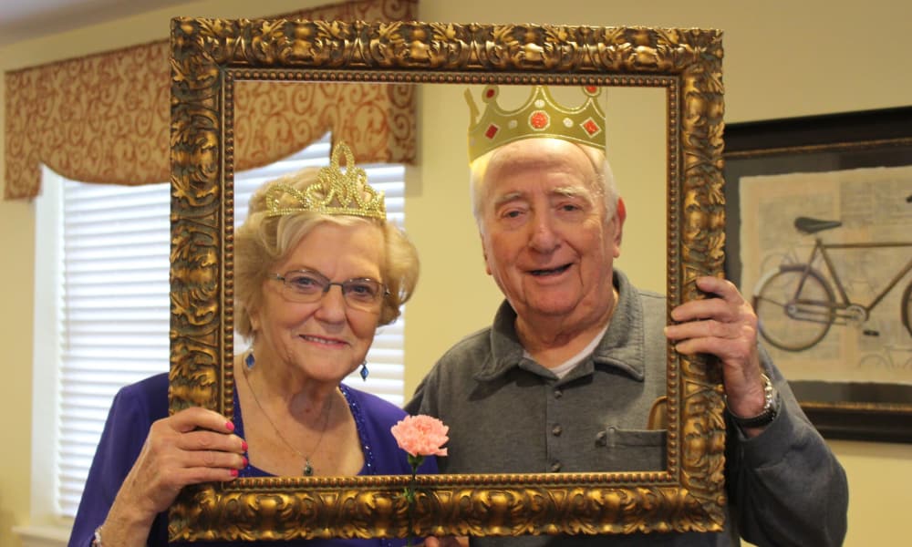 Resident couple posing in a photo frame at The Birches at Newtown in Newtown, Pennsylvania
