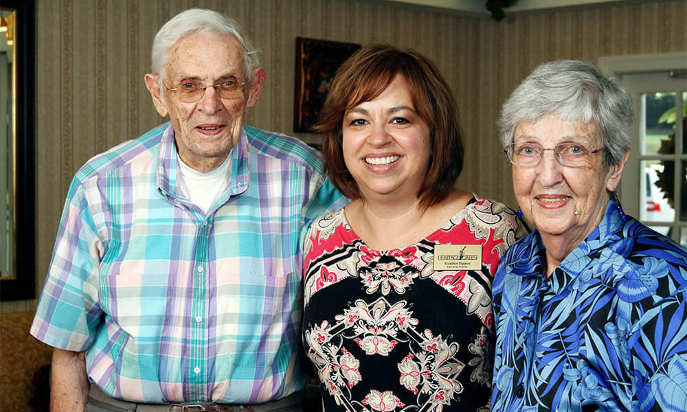 A smiling caretaker and two happy residents at Heritage Green Assisted Living and Memory Care in Lynchburg, Virginia