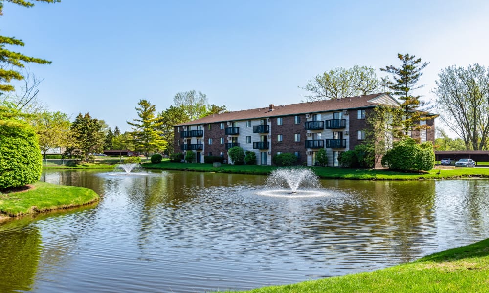 Pond with fountains at Oldebrook Apartments in Wyoming, Michigan