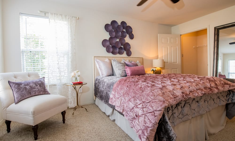 An apartment bedroom with pink bed covers at Colonies at Hillside in Amarillo, Texas