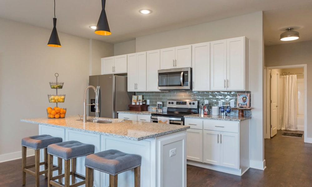 Bar seating next to the kitchen in a model home at Rivertop Apartments in Nashville, Tennessee