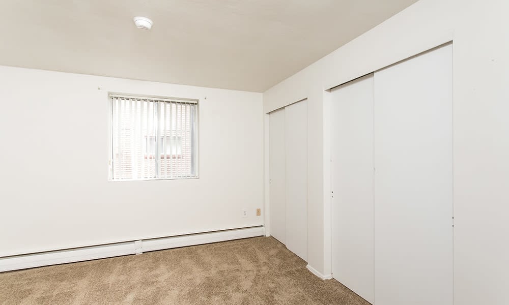 Bedroom space with large closets at Pittsford Garden Apartments in Pittsford, New York