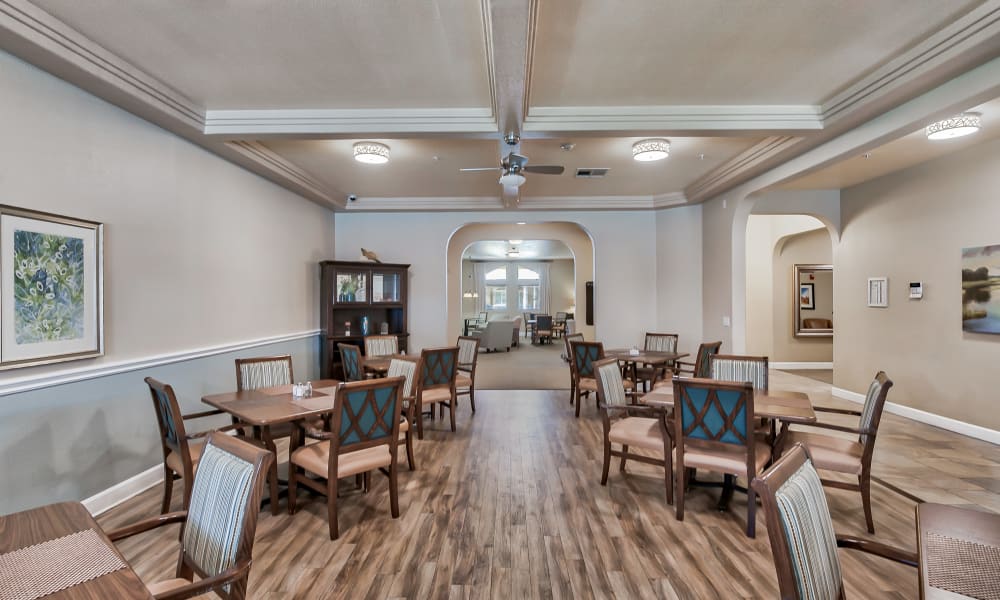 Dining room with dark hardwood floors and elegant wooden furnishings at Sunlit Gardens in Alta Loma, California