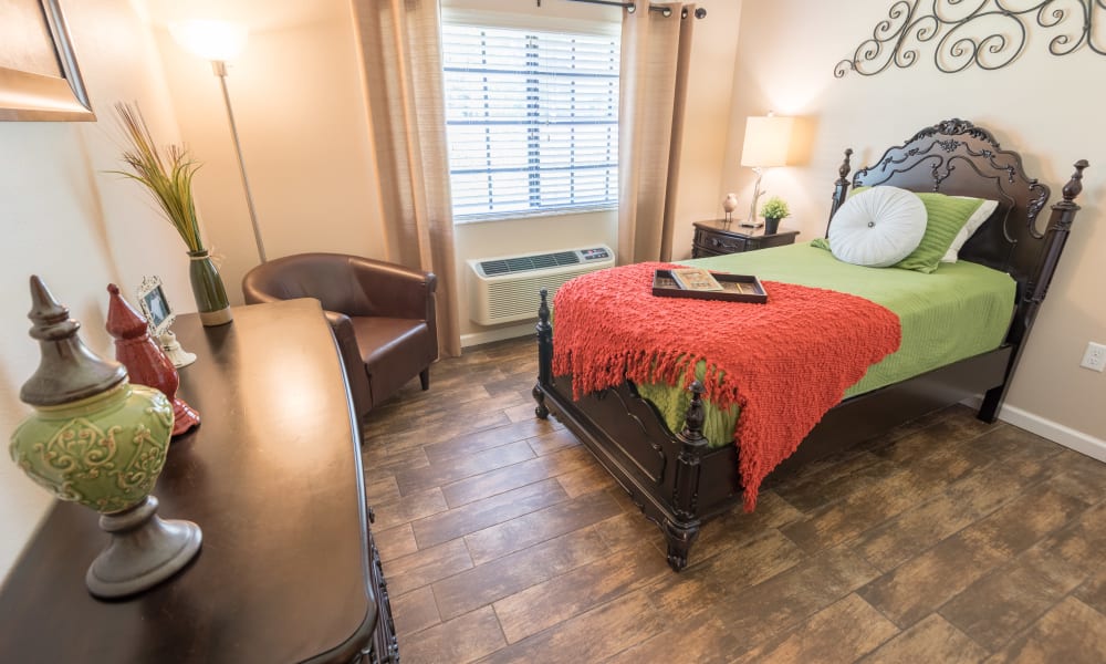 Resident bedroom with hardwood flooring at Inspired Living Sarasota in Sarasota, Florida