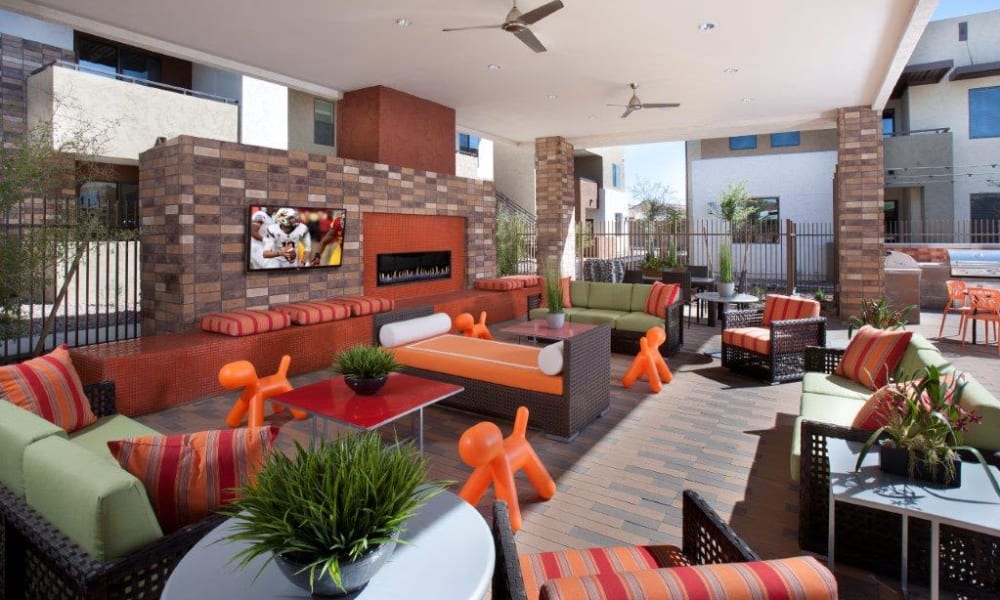 Flatscreen TV and a fireplace at a covered outdoor lounge area at Vive in Chandler, Arizona