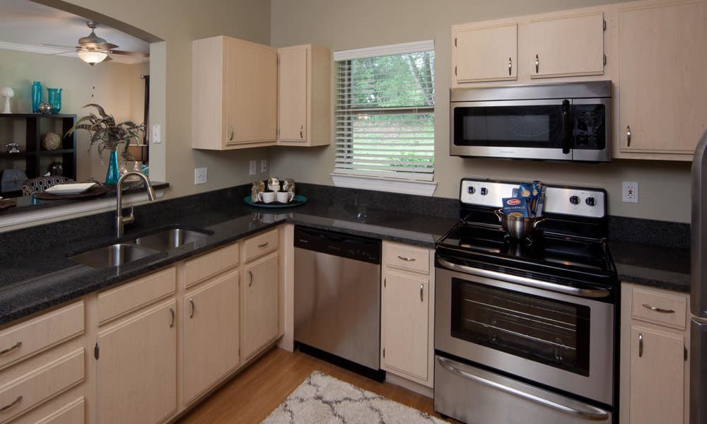 Stainless-steel appliances and an expansive granite countertop in a model home at Wimberly at Deerwood in Jacksonville, Florida