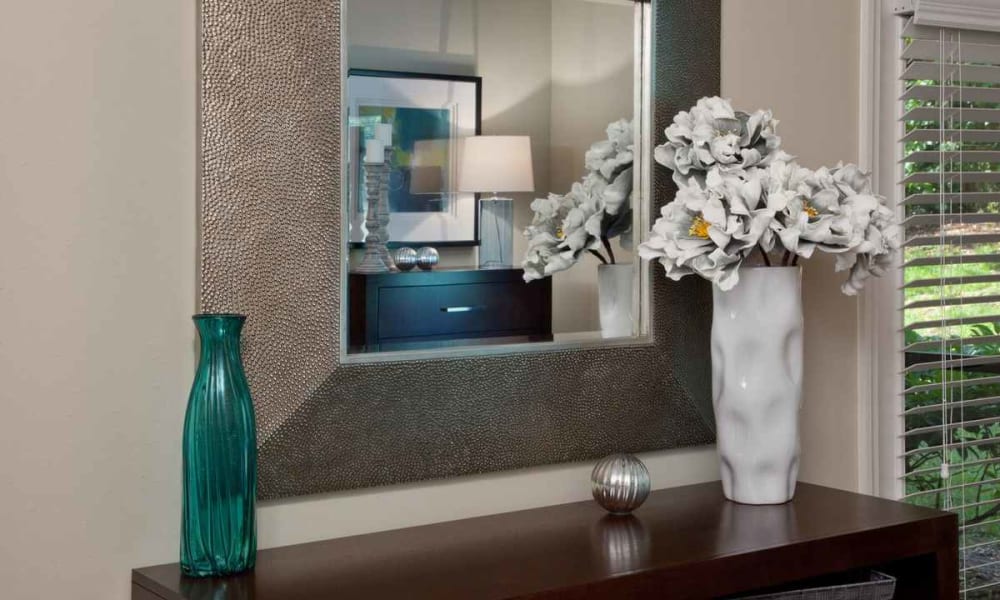 Decorative mirror above vases on an end table in a model home at Wimberly at Deerwood in Jacksonville, Florida