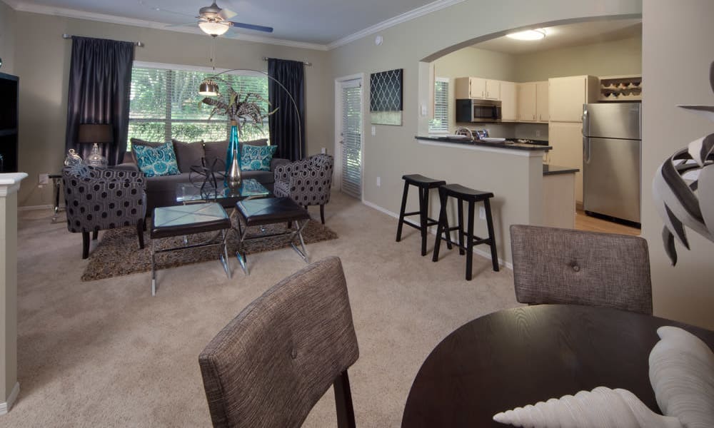 Well-furnished living area with draped windows in a model home at Wimberly at Deerwood in Jacksonville, Florida