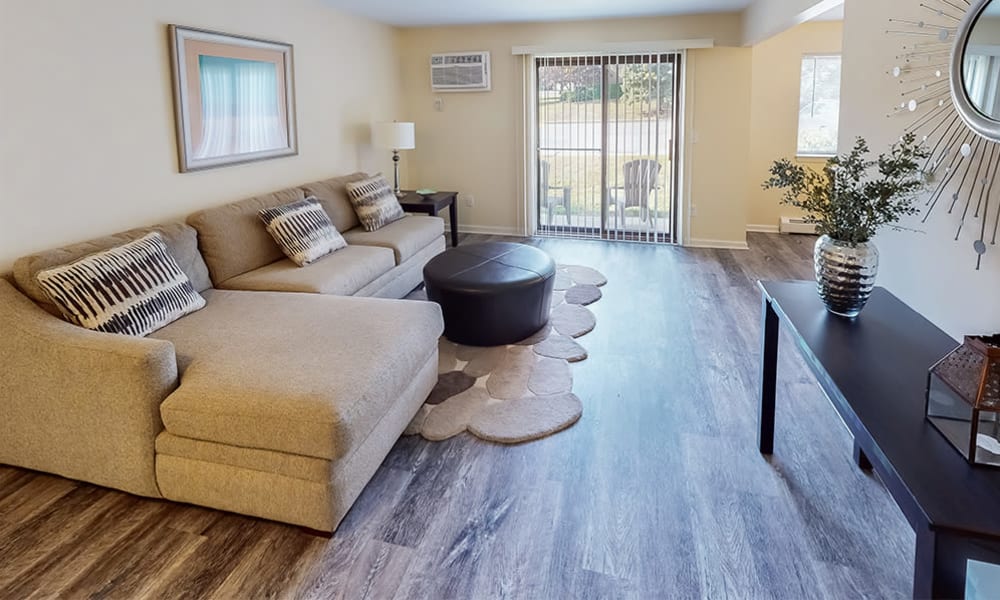 Living room with vinyl plank flooring and sliding door access to a private patio at Imperial Gardens Apartment Homes in Middletown, New York