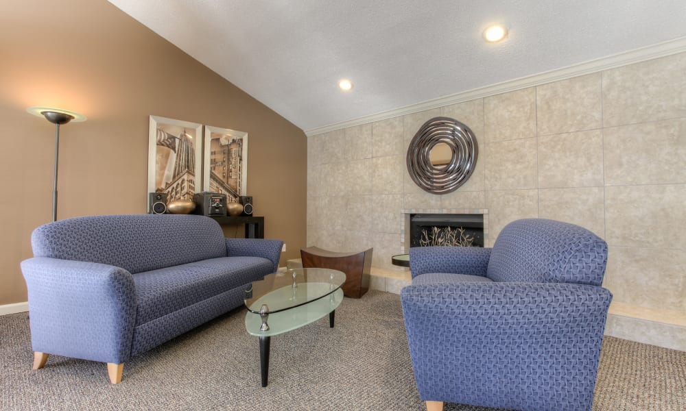 Comfortable clubhouse seating next to a fireplace at Enclave at North Point Apartment Homes in Winston Salem, North Carolina