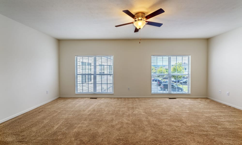 Open bedroom with carpeted floors and ceiling fan at The Waterfront Apartments & Townhomes in Munhall, Pennsylvania