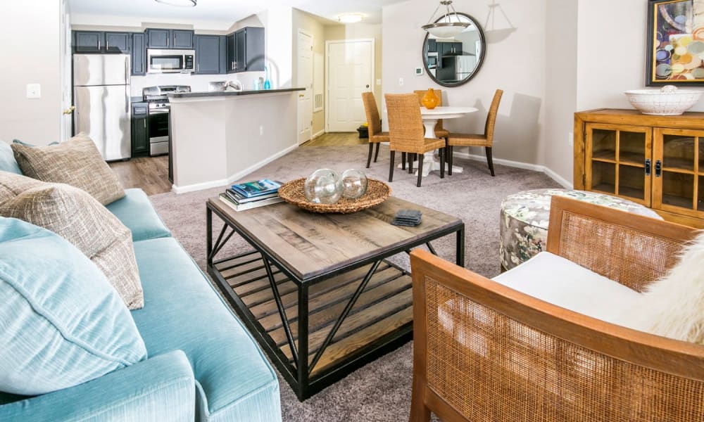 Comfortably furnished living area in a model home's open-concept floor plan at Arbor Ridge Apartments in Owings Mills, Maryland