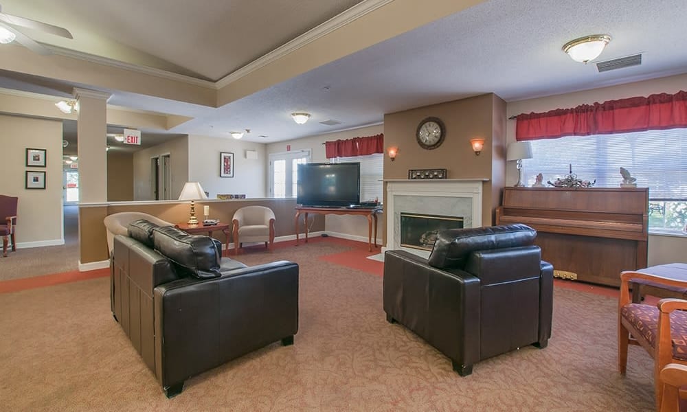Resident living area with leather couches at Randall Residence of Troy in Troy, Ohio