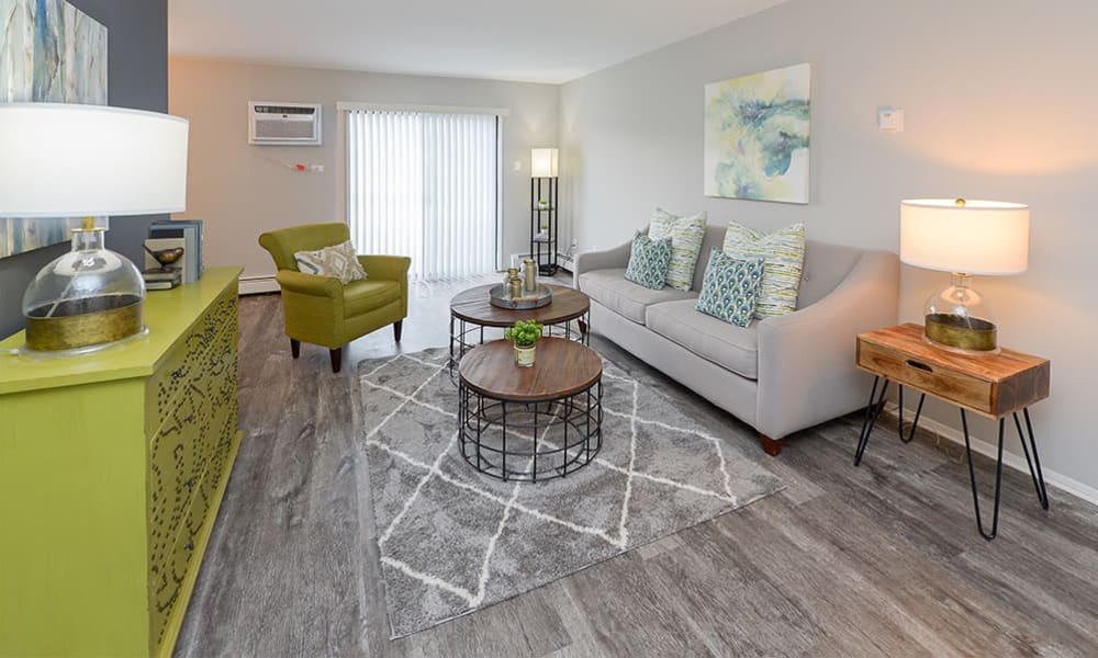 Naturally well-lit living room with vinyl plank flooring at Imperial Gardens Apartment Homes in Middletown, NY