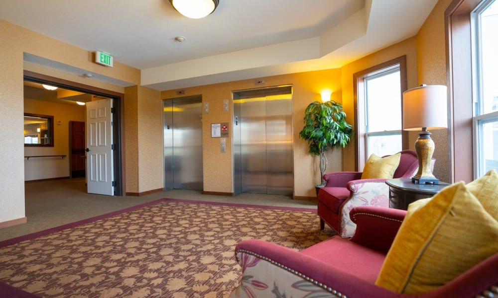 Sunlit room with 2 chairs by the large windows at York Gardens in Edina, Minnesota