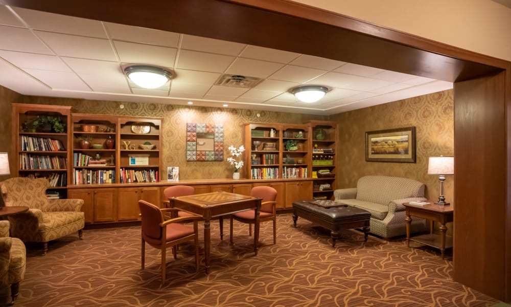 Warmly lit lounge area with several full bookshelves at York Gardens in Edina, Minnesota