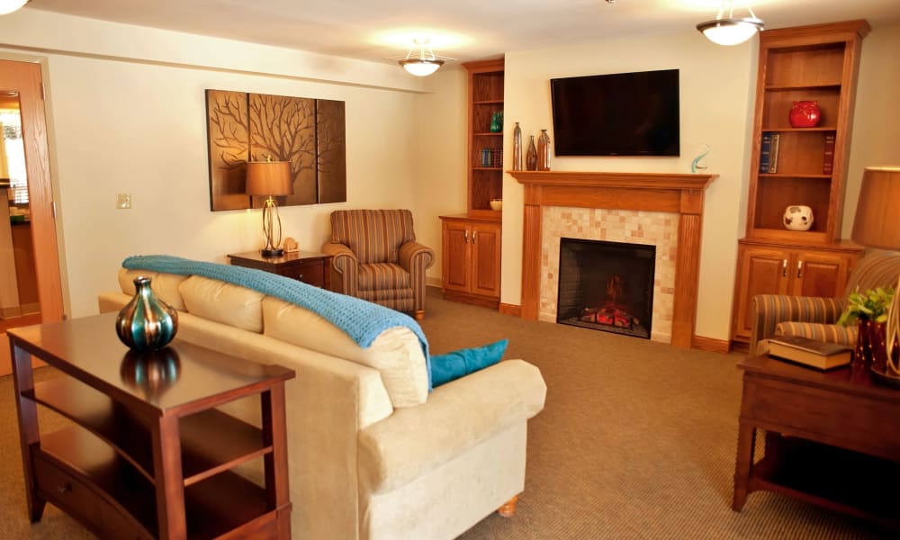 Cozy senior living lounge with a tv and a fireplace at Fair Oaks Health Care Center in Crystal Lake, Illinois