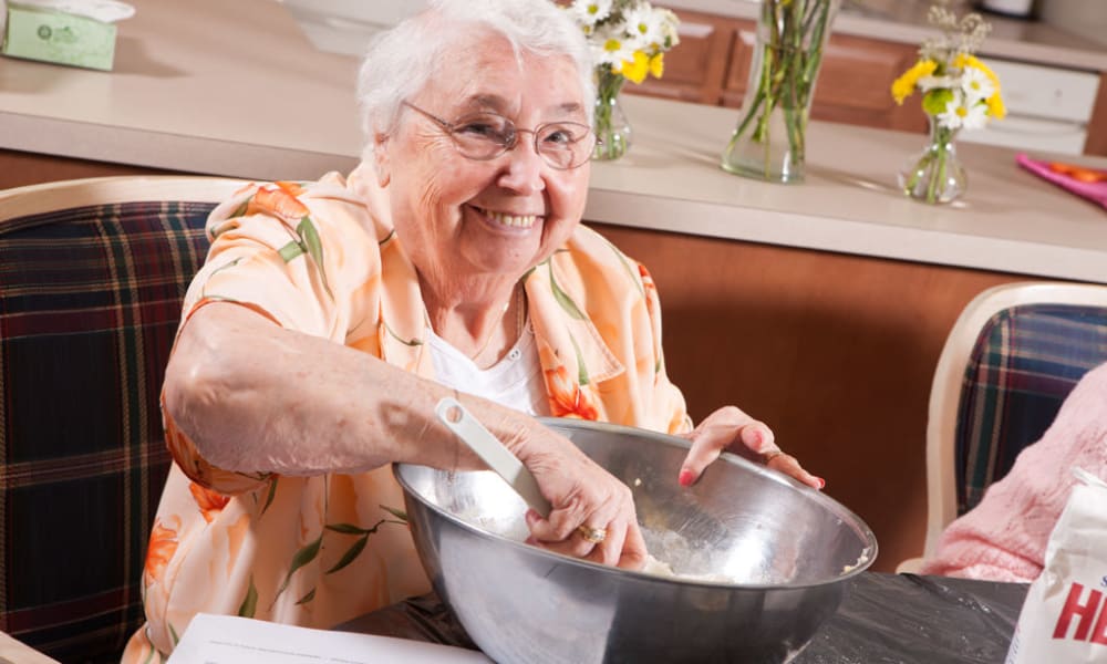 Resident making a delicious meal in a large bowl at The Crossroads at Bon Air in Richmond, Virginia