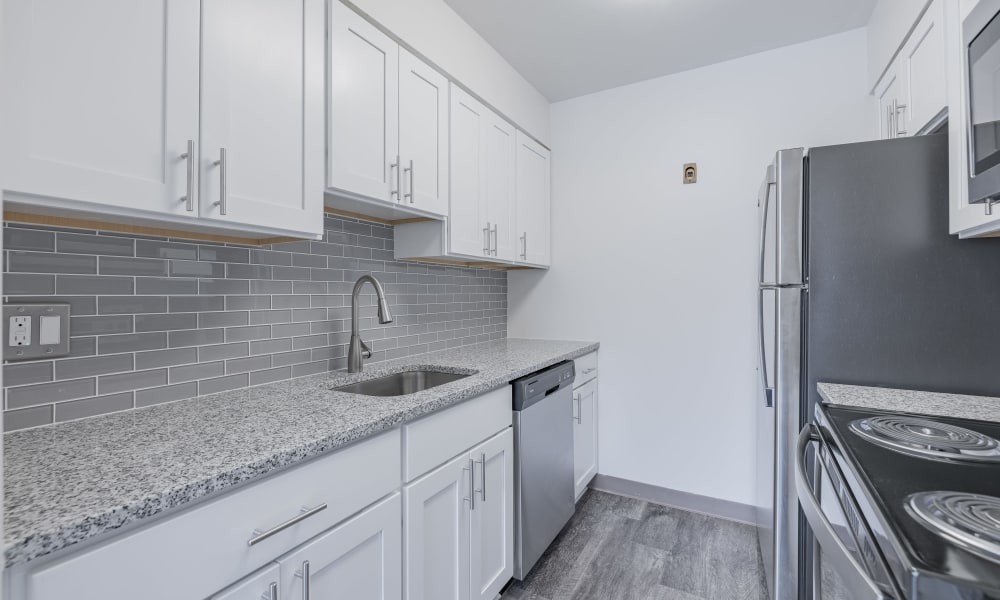 Gourmet kitchen with tile backsplash and vinyl plank flooring at Oak Hill Terrace in Rochester, New York