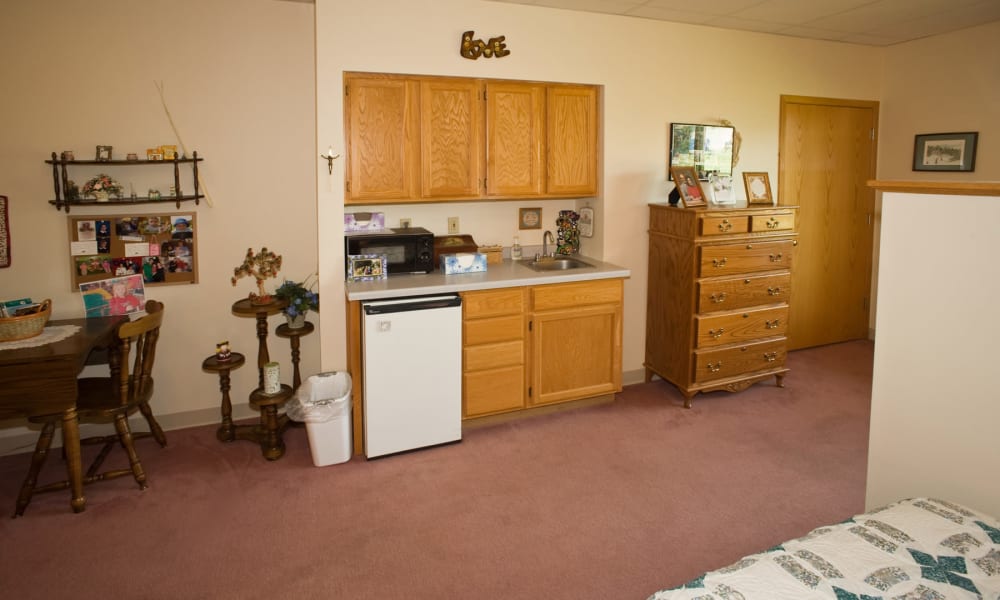 Resident bedroom with kitchen area at Wellington Place at Hartford in Hartford, Wisconsin