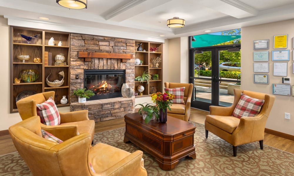 Fireplace with Leather Couches at Quail Park Memory Care Residences of West Seattle in Seattle, Washington