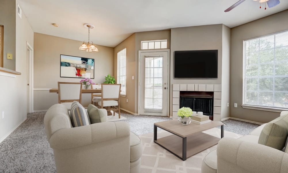 Bright living room with patio door and fireplace at Champion Lake Apartment Homes