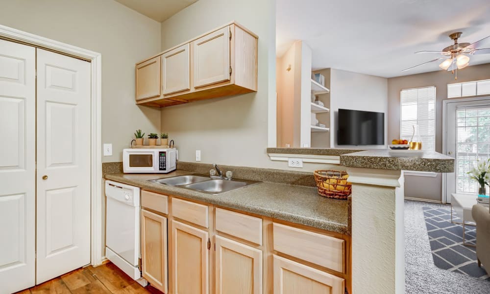 Kitchen with wooden cabinets at Champion Lake Apartment Homes in Shreveport, Louisiana