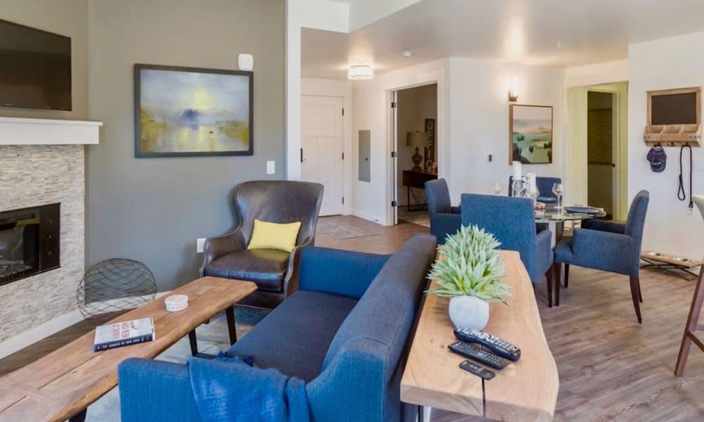 Resident apartment living room with seating and large television at Touchmark at Pilot Butte in Bend, Oregon