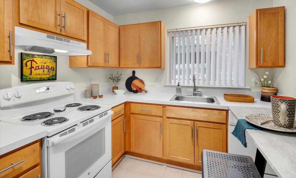 Fully equipped kitchen with white appliances at Fairmont Park Apartments in Farmington Hills, Michigan