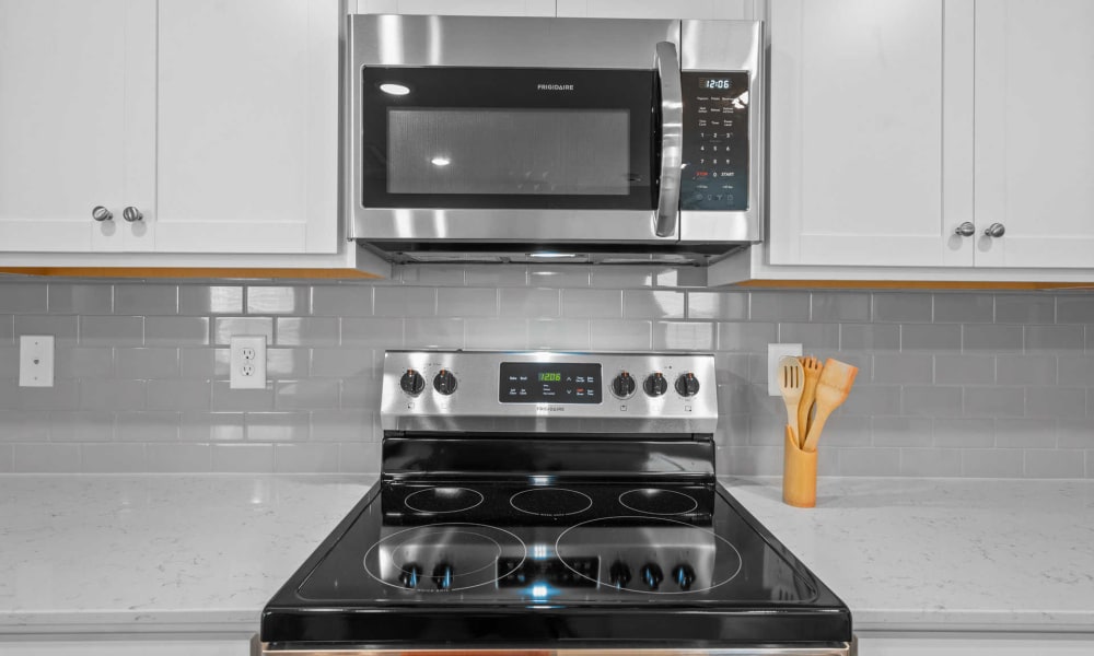 Beautiful stovetop and white cabinetry in a model home's kitchen at Lattitude34 Dillard Creek in Greer, South Carolina