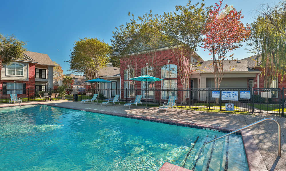 Resident smiling while floating on her back in the swimming pool at Fairmont Oaks Apartments in La Porte, Texas