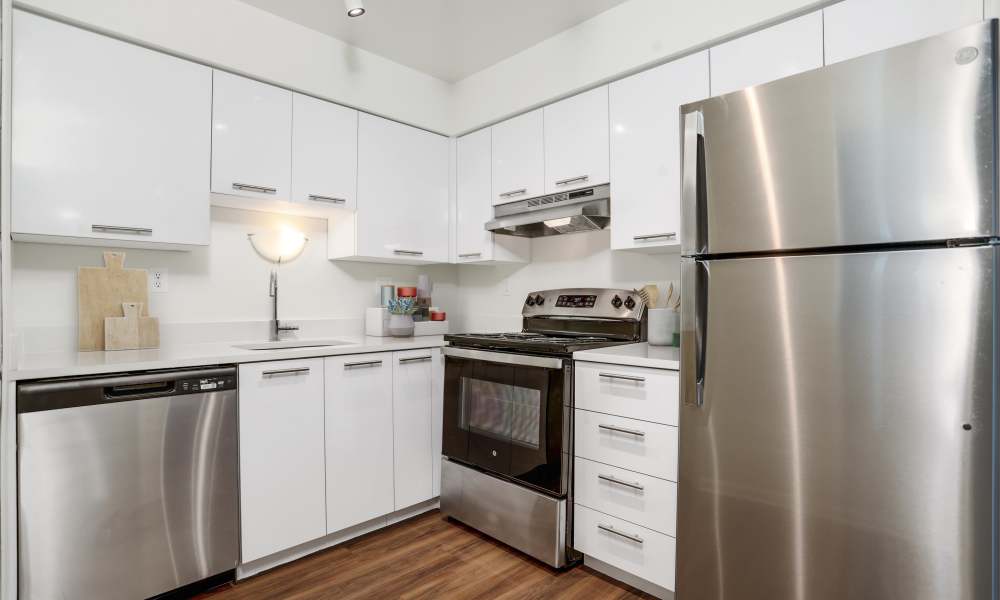 Fully equipped kitchen with white cabinetry and white appliances at Saddle Creek Apartments in Novi, Michigan