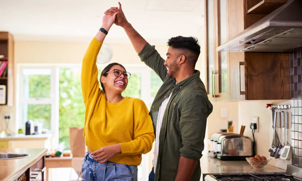 Residents dancing in their new kitchen at a residence of Home Corp Management in Panama City Beach, Florida