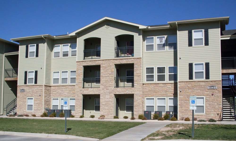 Front view of the apartment with green lawn at Windscape Apartments in Hobbs, New Mexico