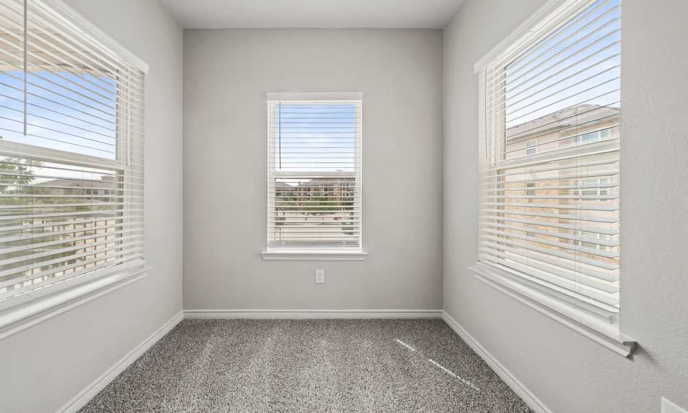 Carpeted dining room with a window on each wall at Sunset Lodge in Odessa, Texas