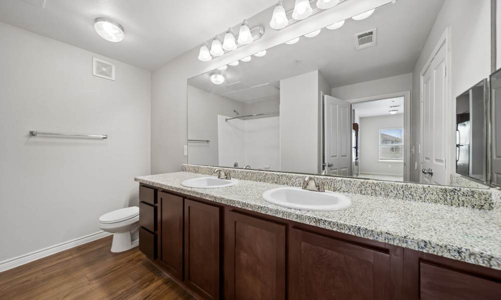Bathroom with dual vanity unit and commode at Sunset Lodge in Odessa, Texas