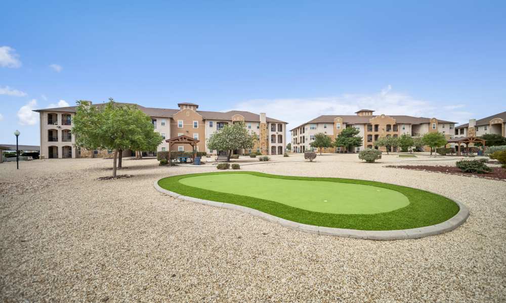 Putting green with apartment buildings in background at Sunset Lodge in Odessa, Texas