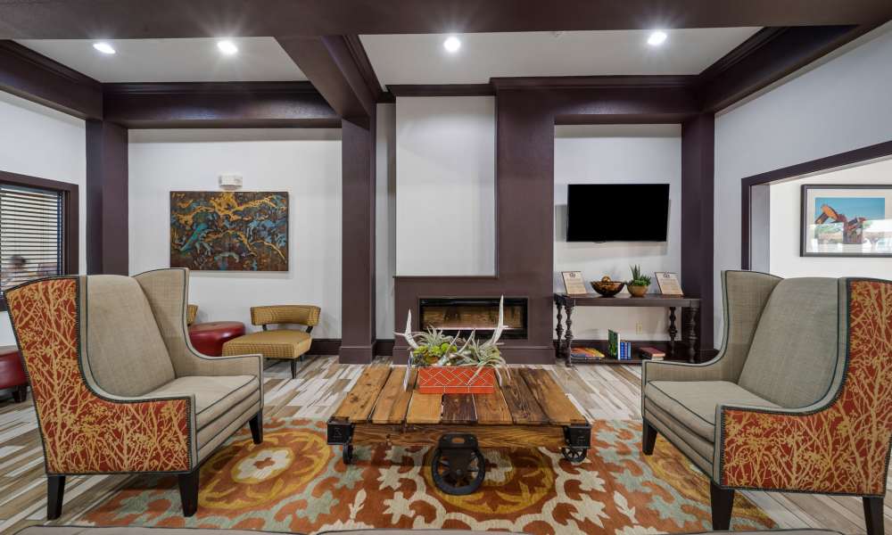 Well decorated clubhouse seating area with mounted TV at Sunset Lodge in Odessa, Texas