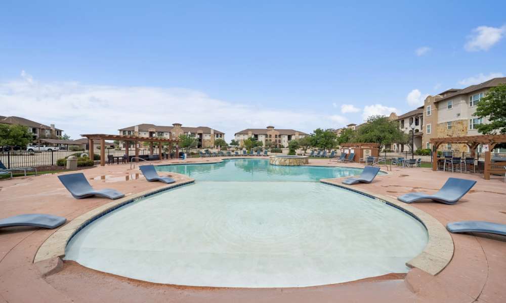 Resort swimming pool with chaise lounges at Sunset Lodge in Odessa, Texas