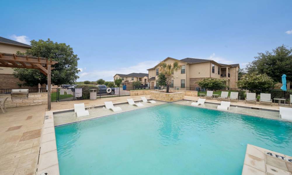 Swimming pool with lounge seating and canopy at Vistas at Red Creek in San Angelo, Texas
