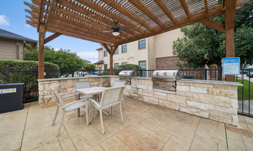Outdoor grilling station with wood canopy near pool at Vistas at Red Creek in San Angelo, Texas