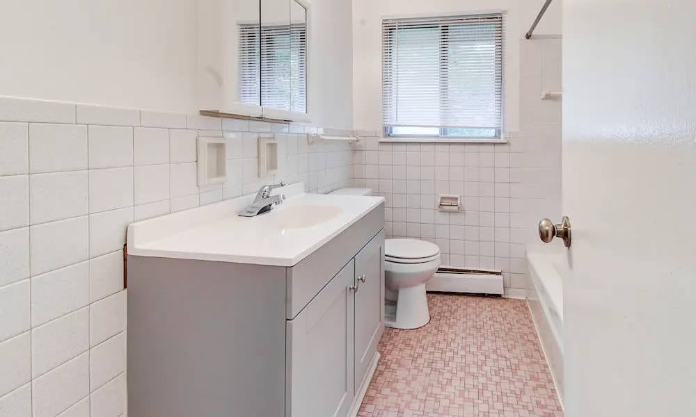Bathroom with vanity, toilet, and bathtub at North Dohr Apartments in Rochester, New York