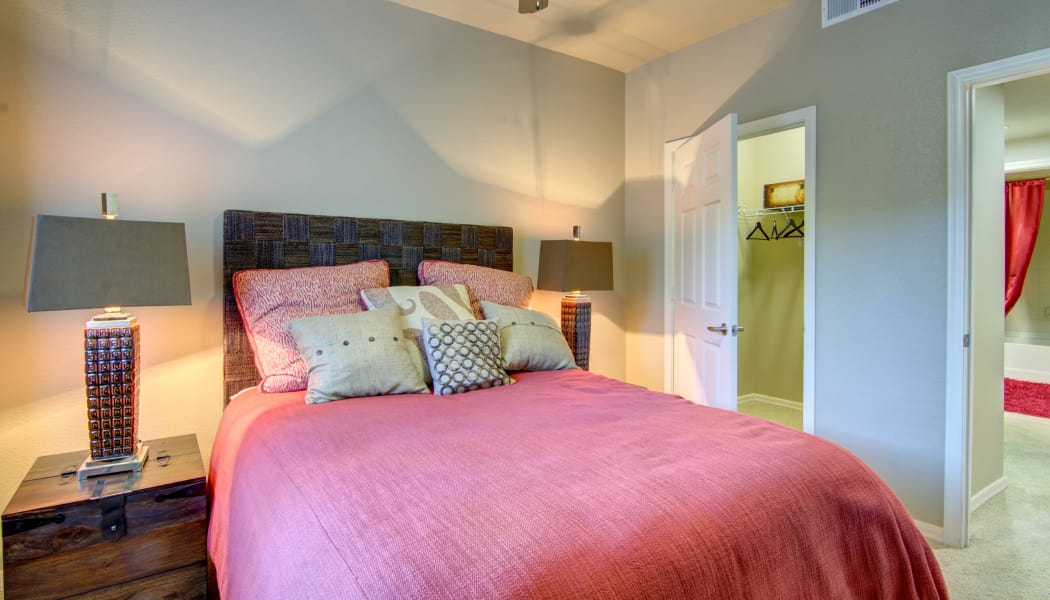 Spacious master bedroom with walk-in closet and en suite bathroom in model home at The Residences at Stadium Village in Surprise, Arizona