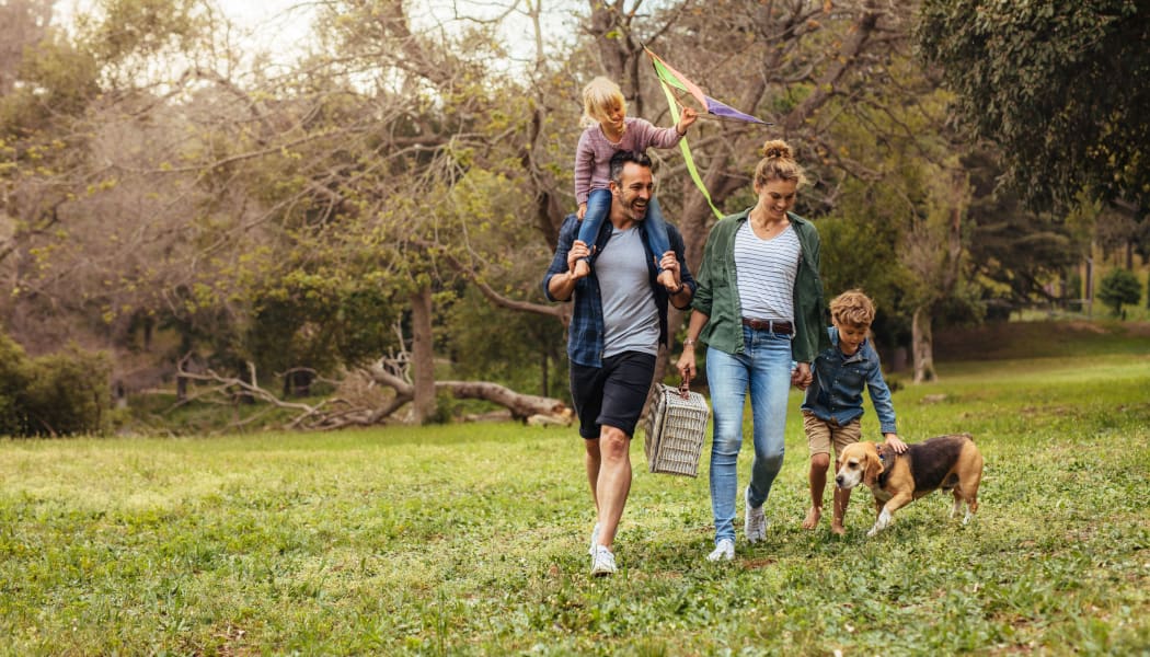 Family walking their dog in a local park in Lubbock, Texas near Tuscany Place