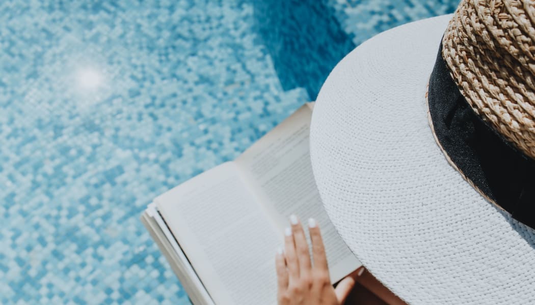 Resident reading by the pool at Pavilions at Northshore in Portland, Texas
