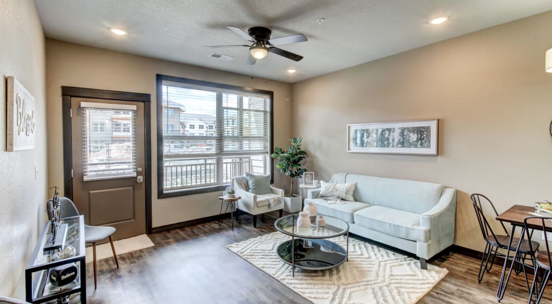 Resident enjoying working in his new living room at Timnath Trail at Riverbend Apartment Homes