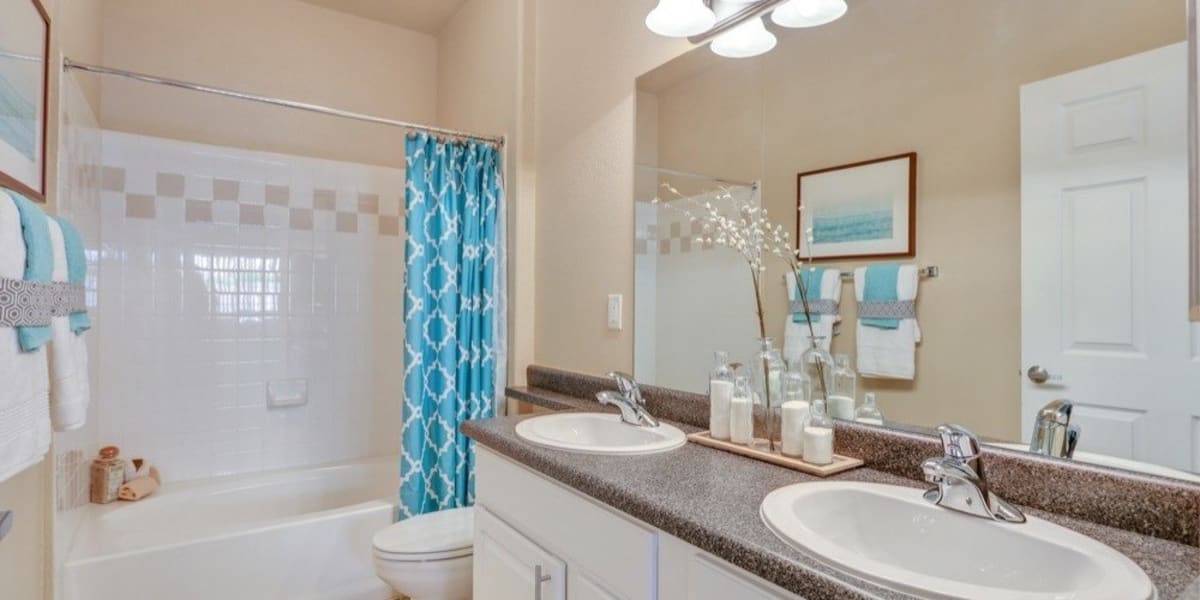 Cute bathroom with double sinks and a large vanity mirror at Resort at University Park in Colorado Springs, Colorado